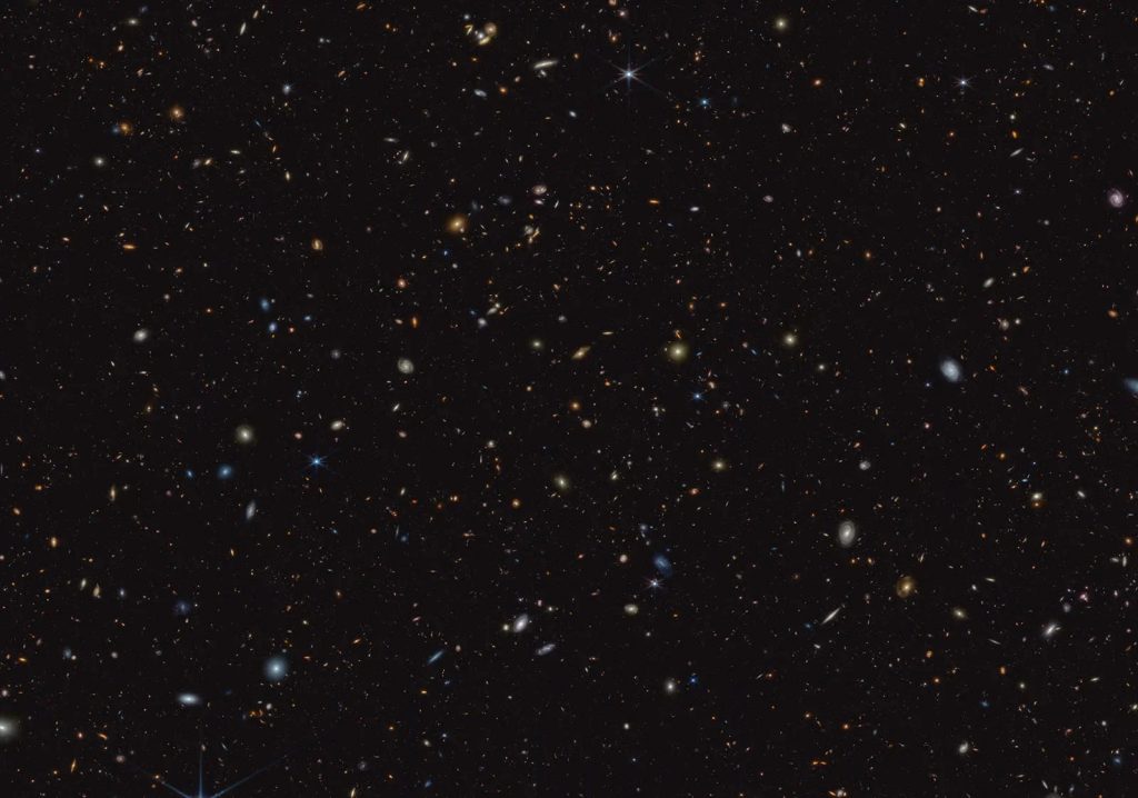 "Hình ảnh hồng ngoại này từ kính viễn vọng James Webb (JWST) của NASA được chụp cho chương trình JADES. Nó cho thấy một phần của bầu trời được gọi là GOODS-South, đã được kính viễn vọng không gian Hubble và các đài quan sát khác nghiên cứu kỹ lưỡng. Hơn 45,000 thiên hà có thể được nhìn thấy ở đây." | Credits: NASA, ESA, CSA, Brant Robertson (UC Santa Cruz), Ben Johnson (CfA), Sandro Tacchella (Cambridge), Marcia Rieke (Đại học Arizona), Daniel Eisenstein (CfA). Xử lý hình ảnh: Alyssa Pagan (STScI)